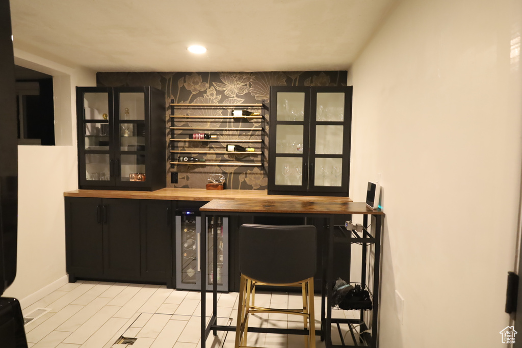 Indoor dry bar featuring wine cooler and recessed lighting