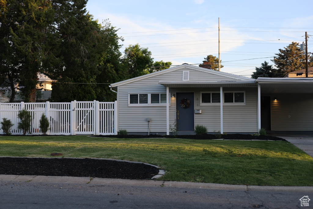 View of front of home featuring an attached carport and driveway