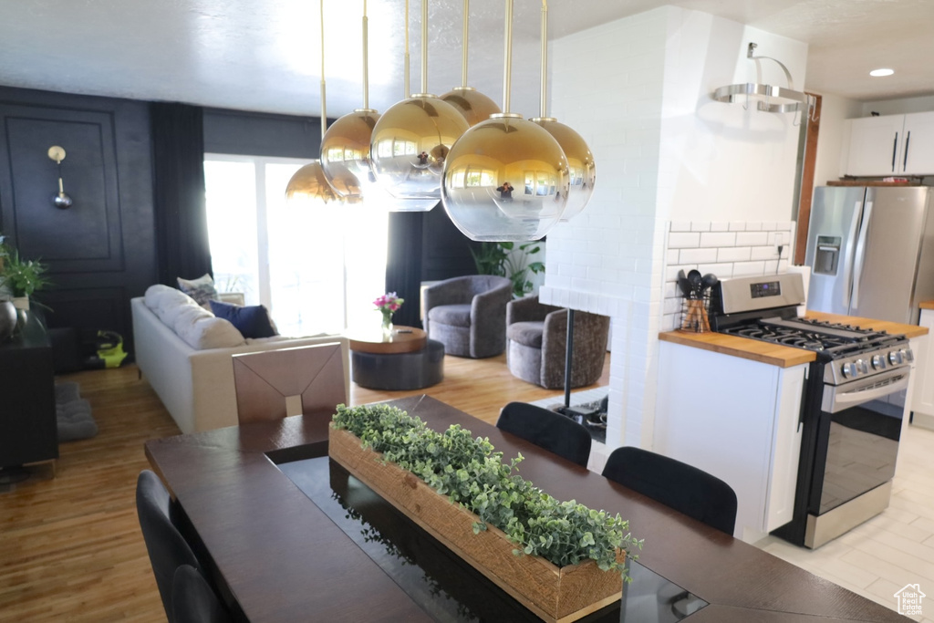 Dining space with light wood-style floors, recessed lighting, and a chandelier