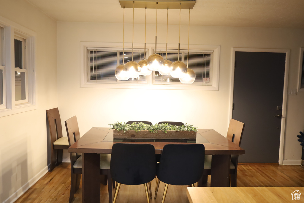 Dining area featuring wood finished floors, a chandelier, and baseboards