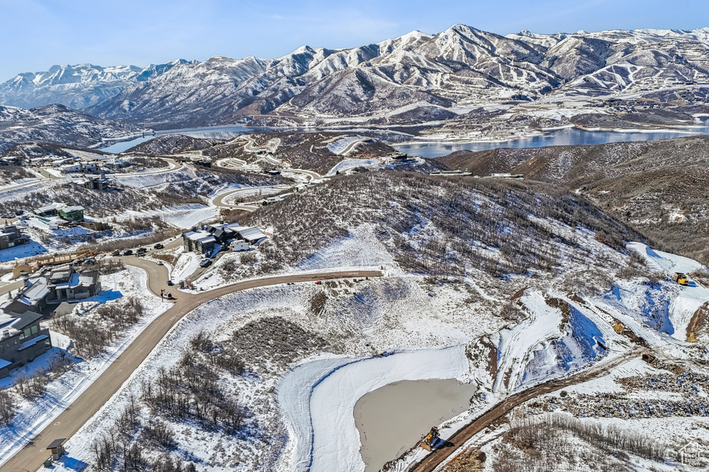 Snowy aerial view with a water and mountain view