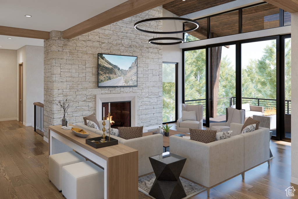 Living area with beam ceiling, healthy amount of natural light, wood finished floors, baseboards, and a fireplace
