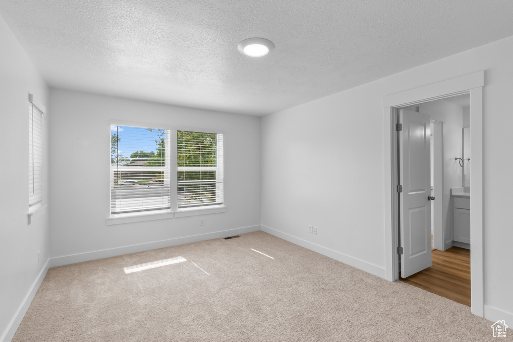 Unfurnished bedroom featuring carpet flooring, a textured ceiling, and baseboards