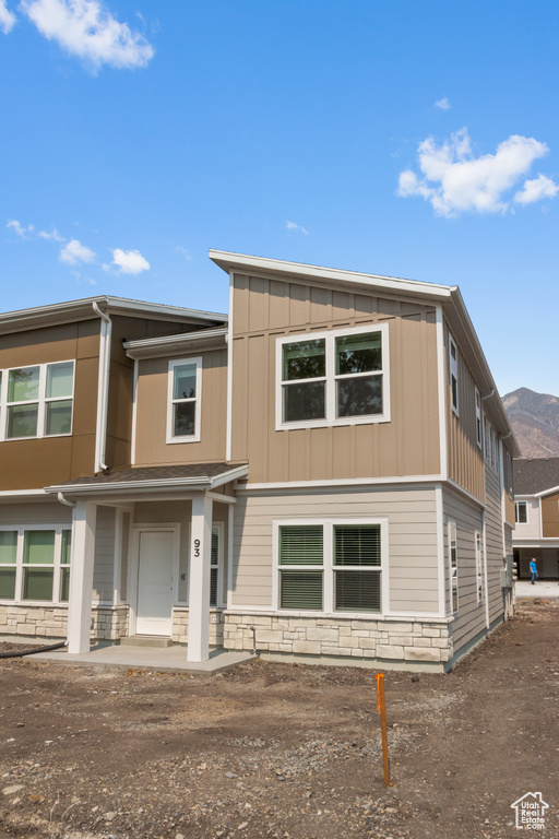 View of front of home featuring board and batten siding and stone siding