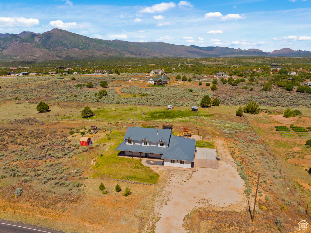 Aerial view of property and surrounding area featuring a mountain backdrop