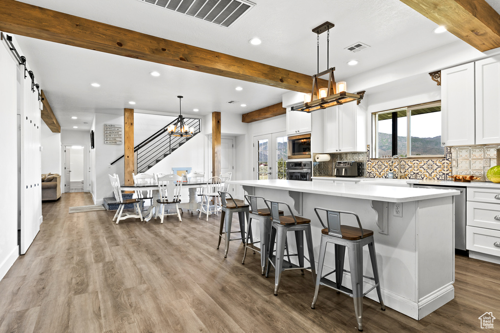 Kitchen with stainless steel appliances, recessed lighting, a chandelier, decorative backsplash, and beam ceiling
