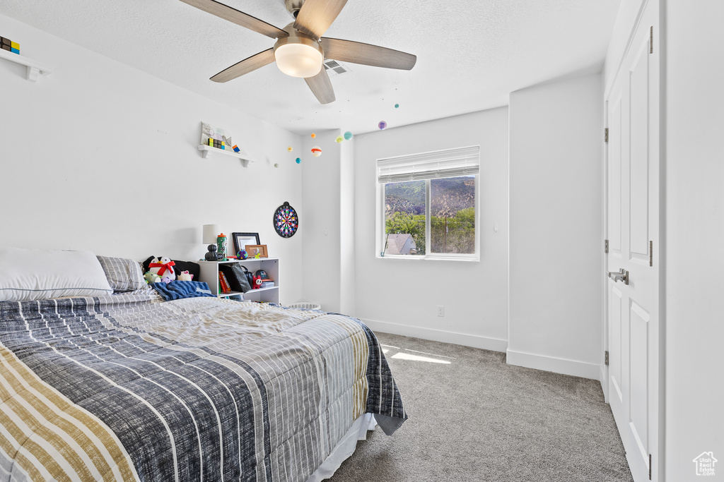 Carpeted bedroom featuring baseboards and a ceiling fan