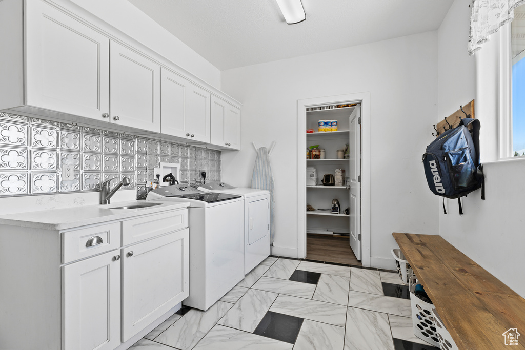 Laundry area featuring independent washer and dryer and cabinet space