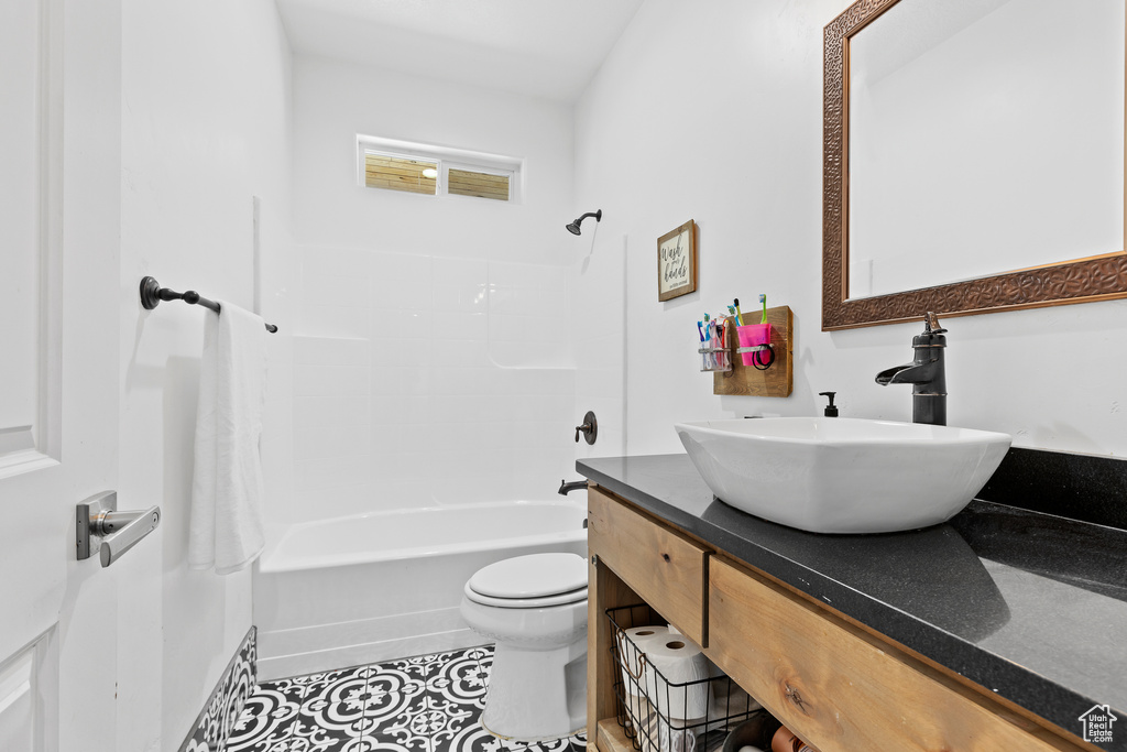 Bathroom with vanity, toilet, tile patterned flooring, and tub / shower combination