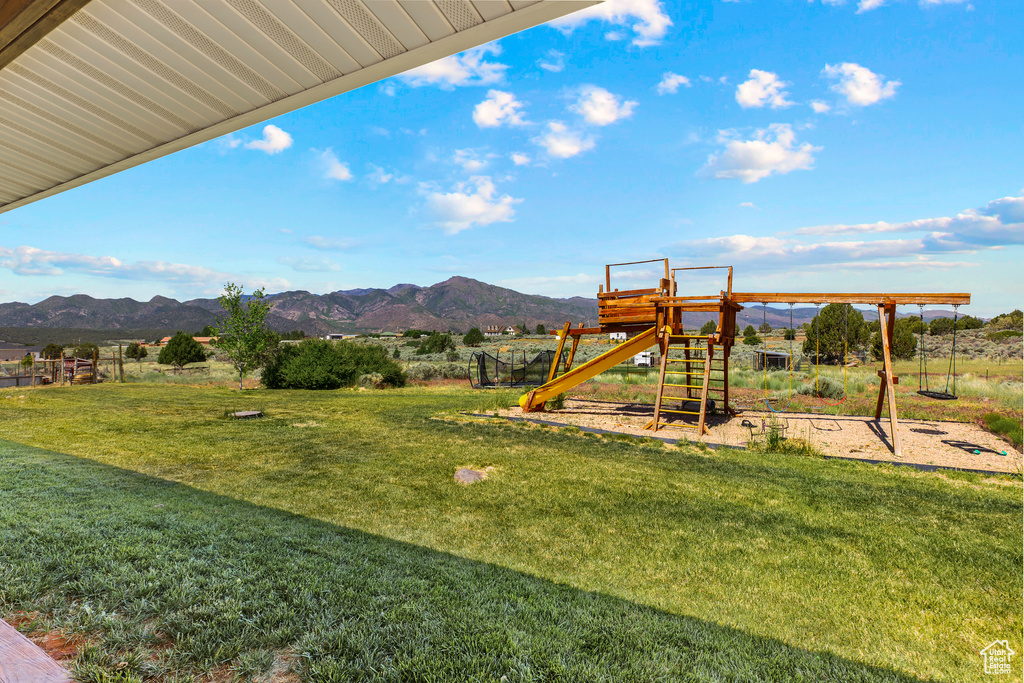 View of green lawn with a playground and a mountain view