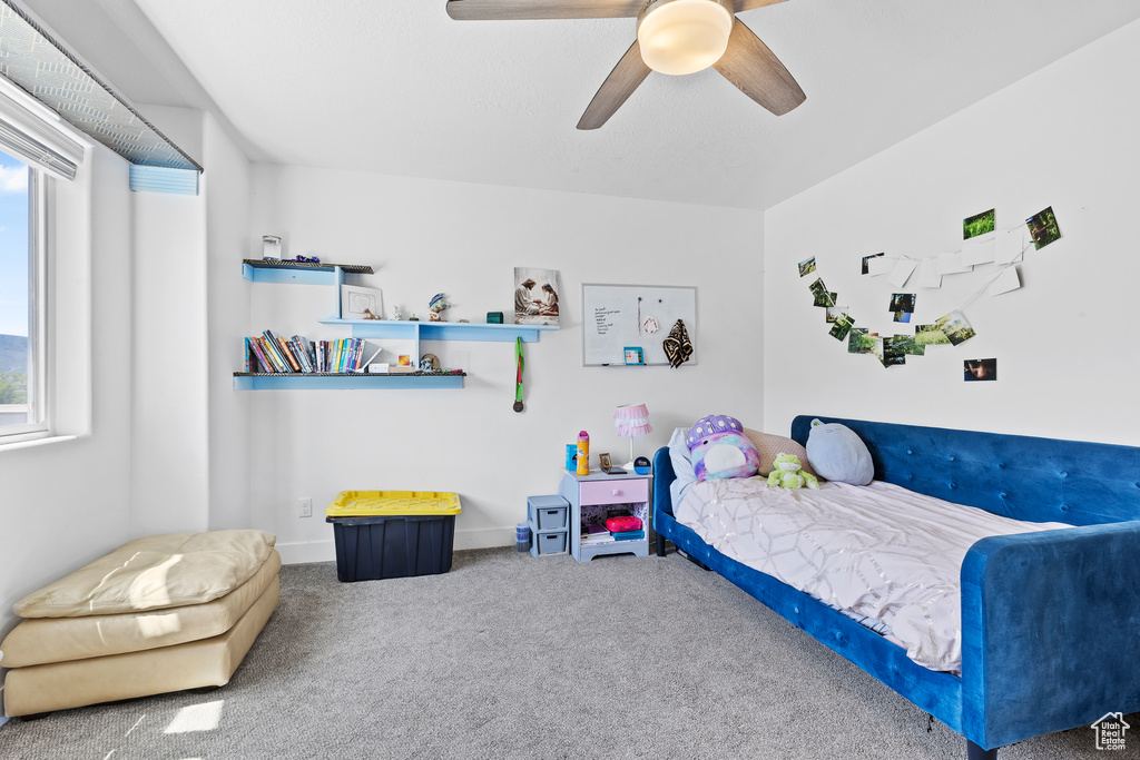 Bedroom featuring carpet floors, multiple windows, ceiling fan, and baseboards