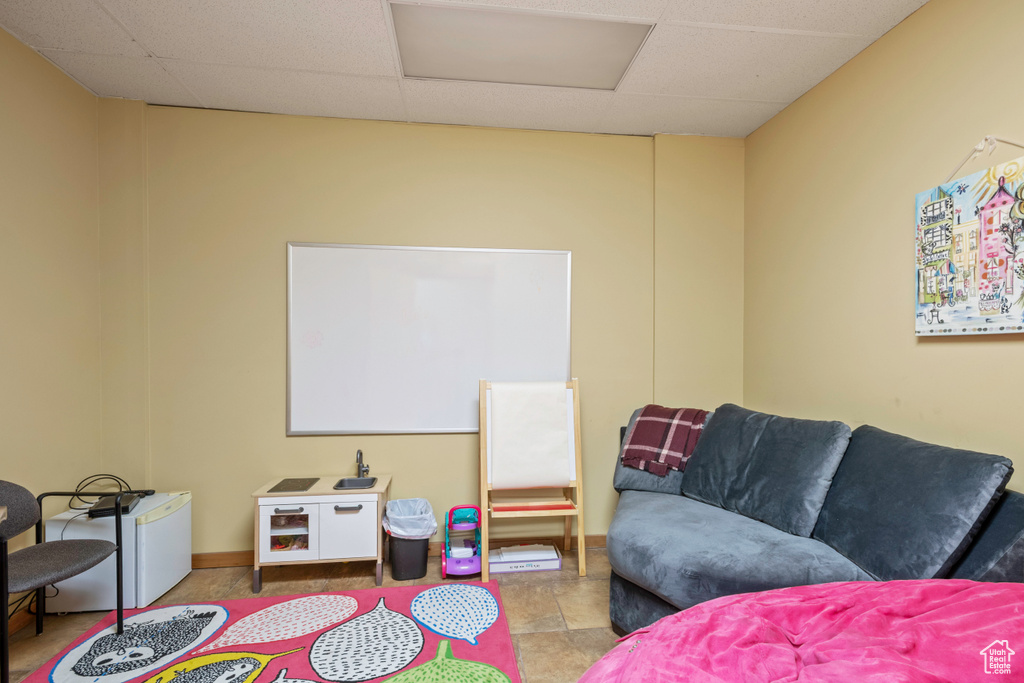 Game room with attic access, a drop ceiling, and baseboards