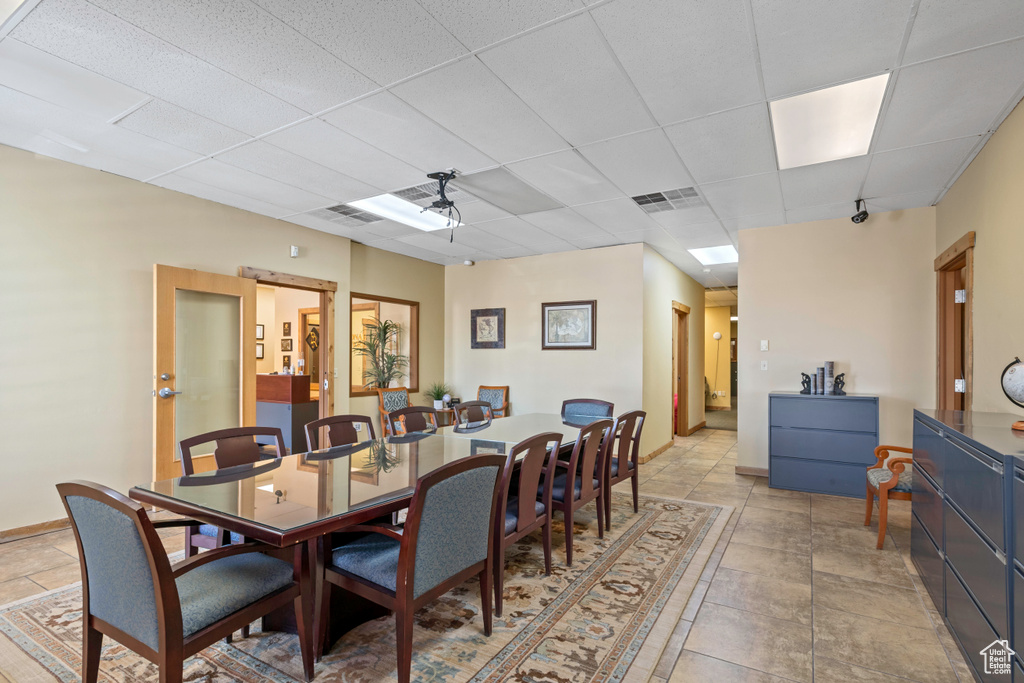 Dining space with a paneled ceiling and baseboards