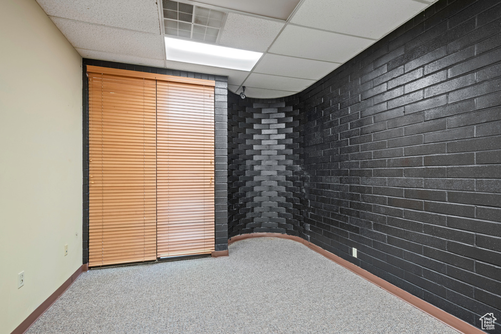 Carpeted empty room with baseboards and a paneled ceiling
