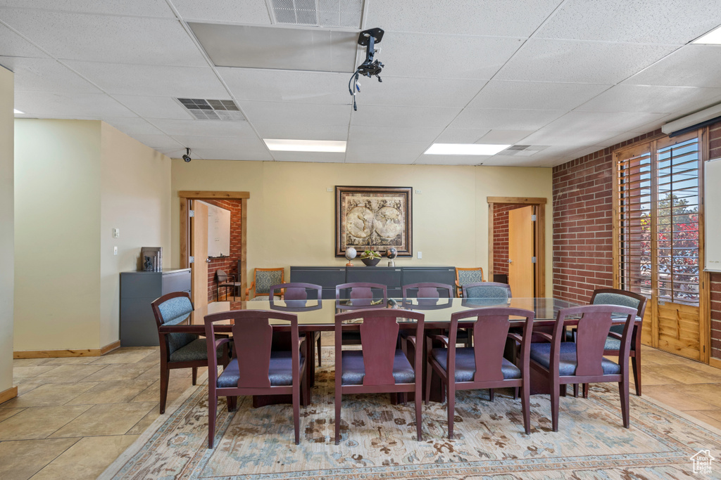 Dining space featuring a drop ceiling and baseboards