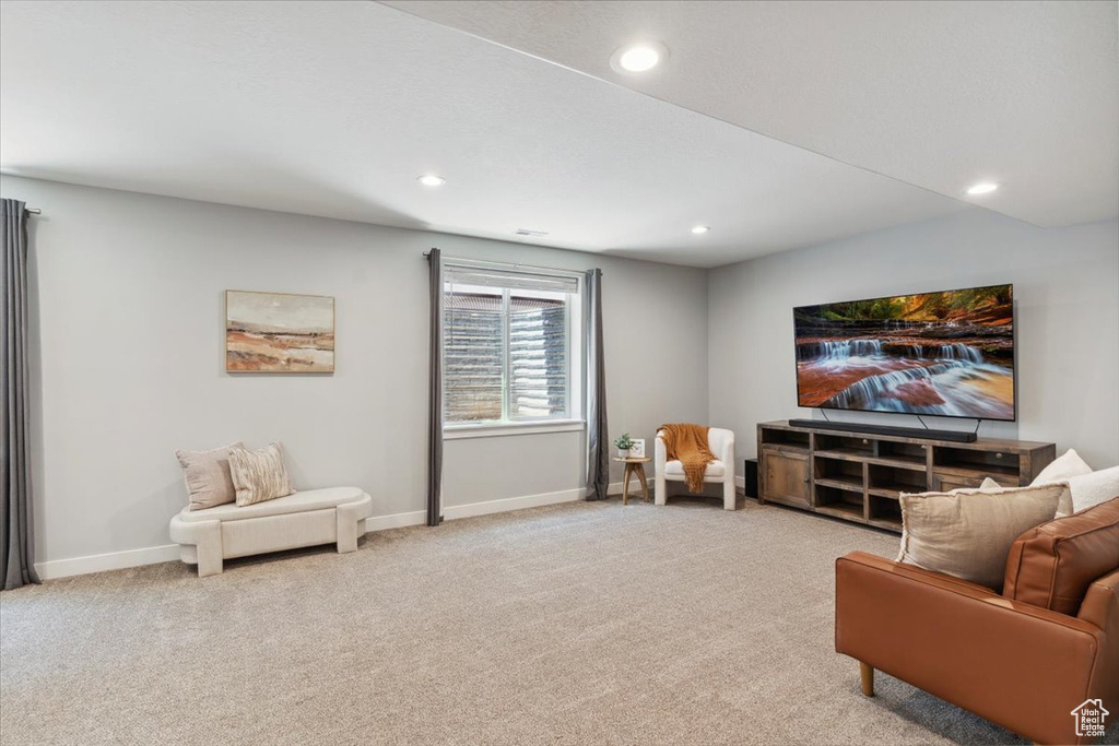 Living area featuring light colored carpet, baseboards, and recessed lighting