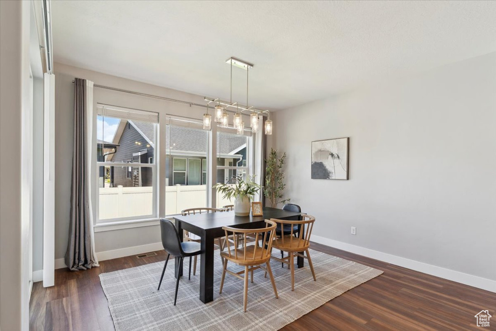 Dining area with dark wood-style floors and baseboards