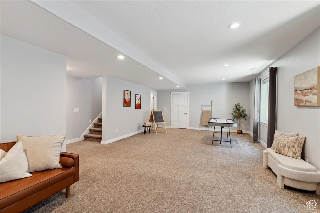 Sitting room featuring recessed lighting, light colored carpet, stairs, and baseboards