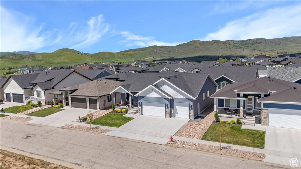 View of front of property featuring a residential view, concrete driveway, and stone siding