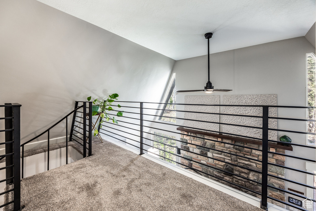 Stairway with carpet floors and ceiling fan