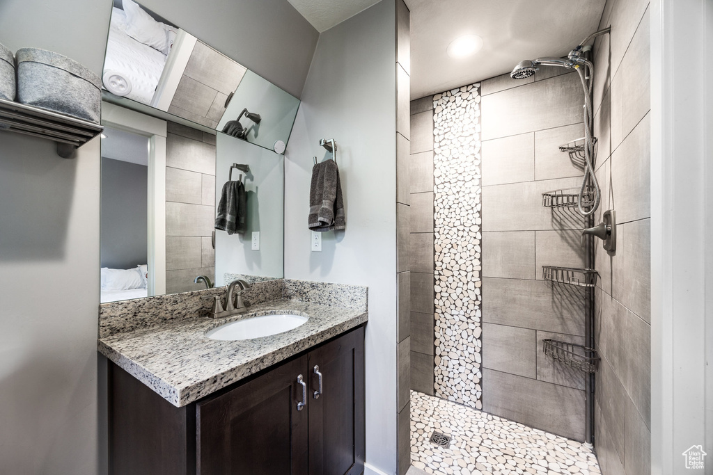 Full bathroom featuring tiled shower and vanity
