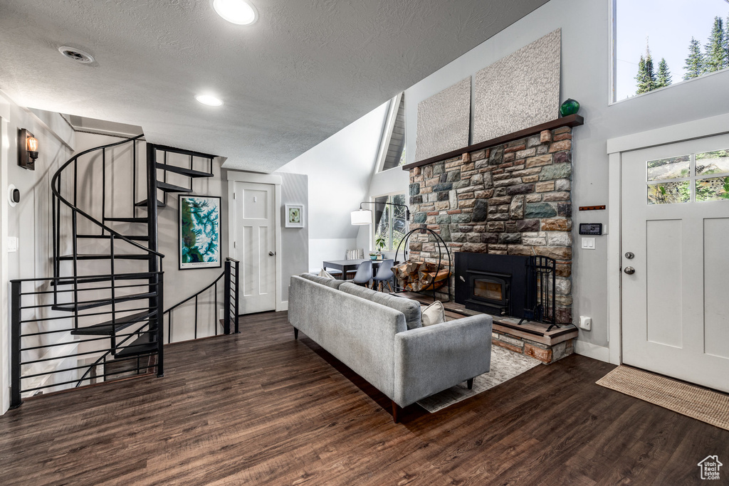 Living room featuring wood finished floors, a textured ceiling, stairway, and baseboards