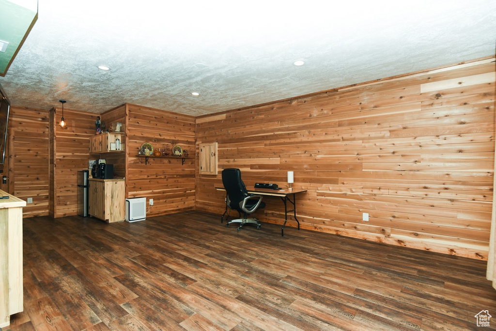 Unfurnished office with dark wood-style floors, recessed lighting, and wood walls
