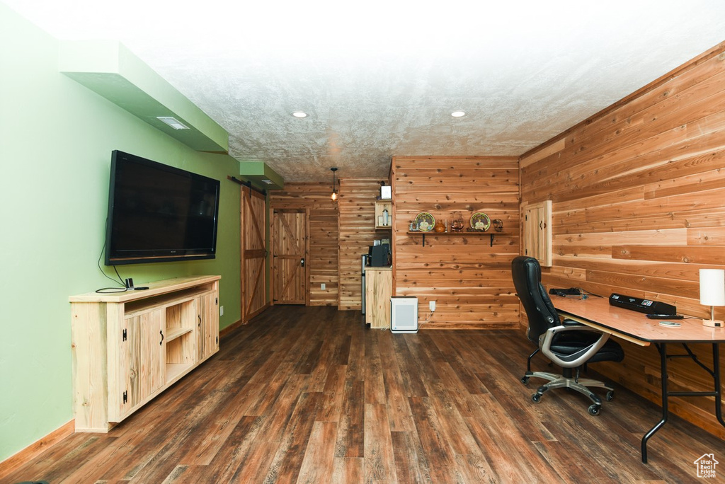Home office with dark wood finished floors, wood walls, recessed lighting, and baseboards