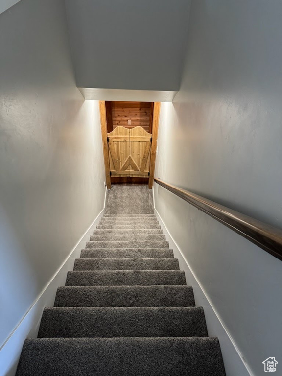 Staircase featuring baseboards and carpet floors
