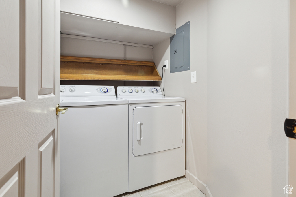 Washroom featuring independent washer and dryer, electric panel, and light tile patterned floors