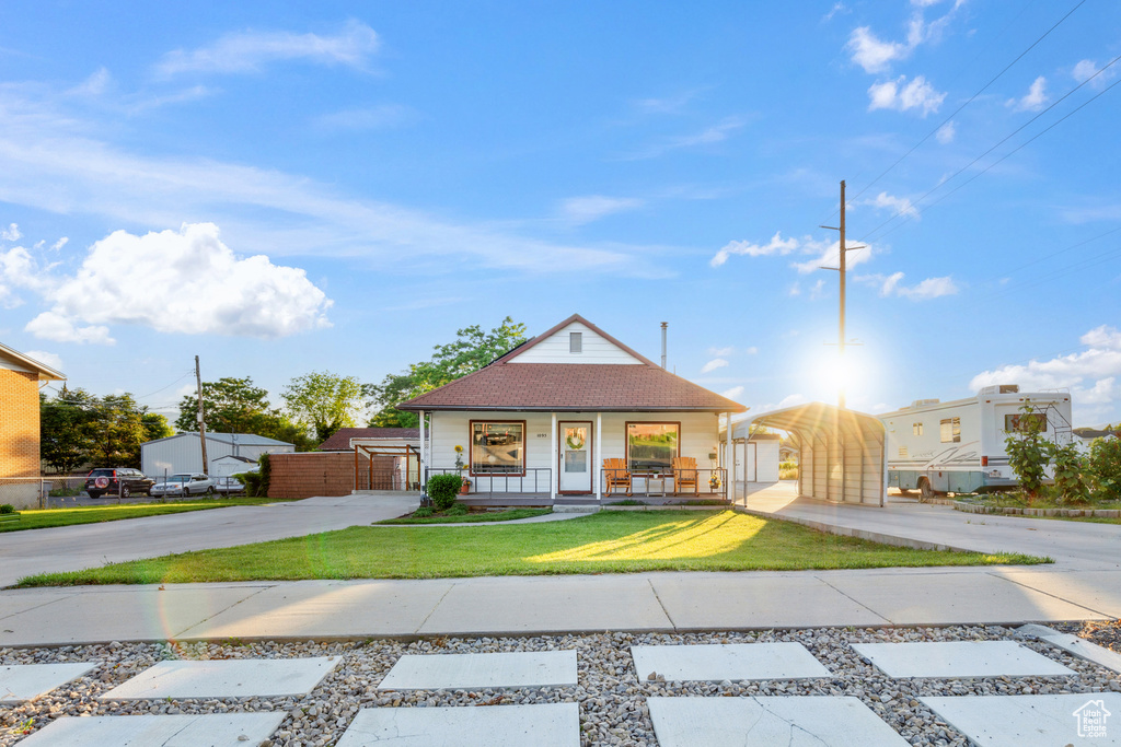 Bungalow with covered porch, concrete driveway, a gate, a carport, and a shingled roof