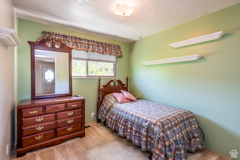 Bedroom featuring a textured ceiling and carpet floors