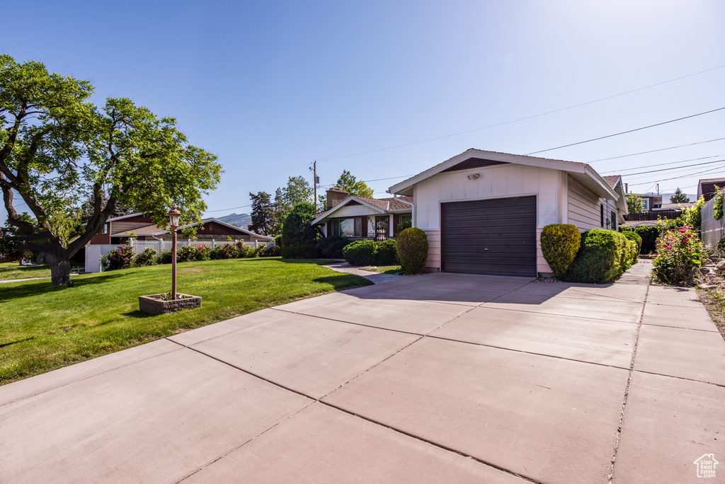 View of front of property with driveway, an attached garage, and a front yard