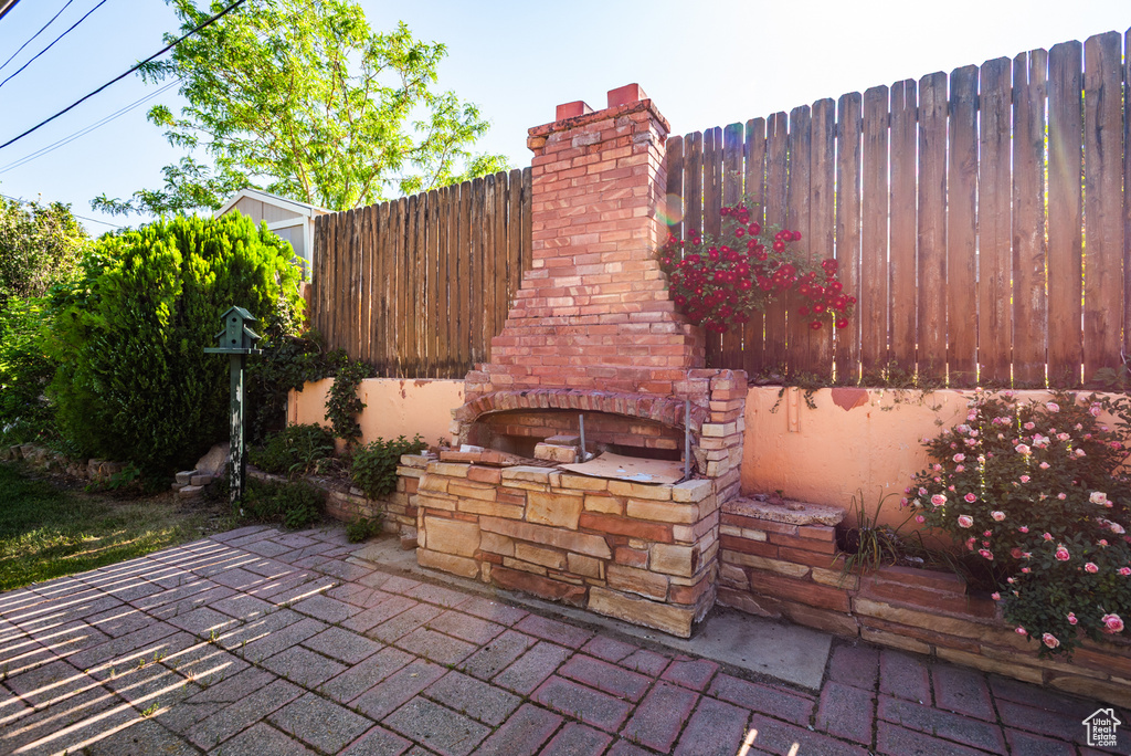 View of patio featuring an outdoor brick fireplace
