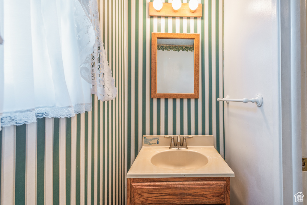 Bathroom with wallpapered walls and vanity