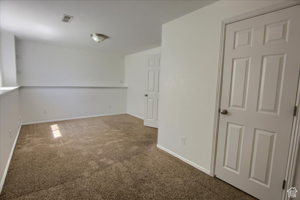 Spare room featuring carpet flooring and baseboards