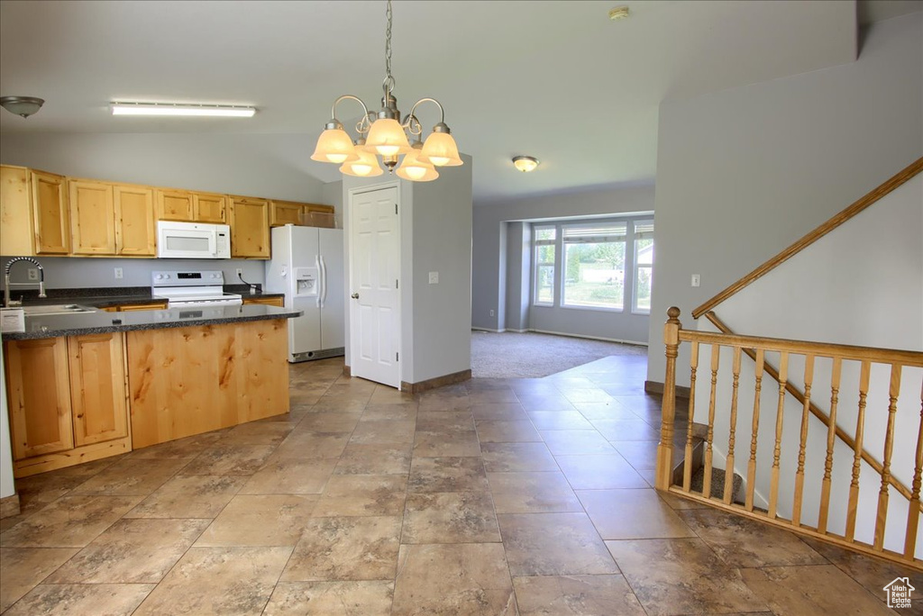 Kitchen featuring white appliances, a sink, a chandelier, vaulted ceiling, and decorative light fixtures