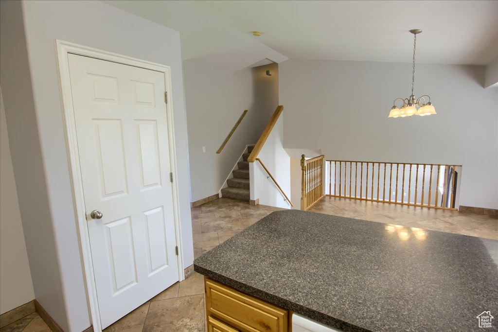 Kitchen with dark countertops, a chandelier, and pendant lighting