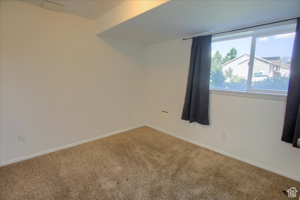 Spare room featuring carpet and baseboards