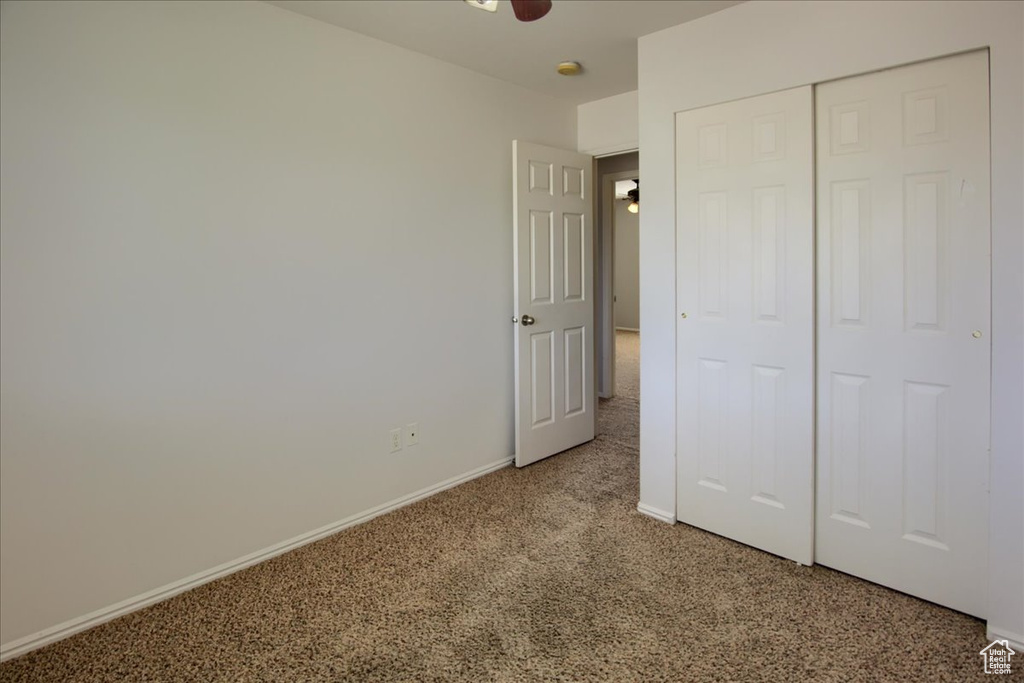 Unfurnished bedroom featuring carpet floors, baseboards, and a closet