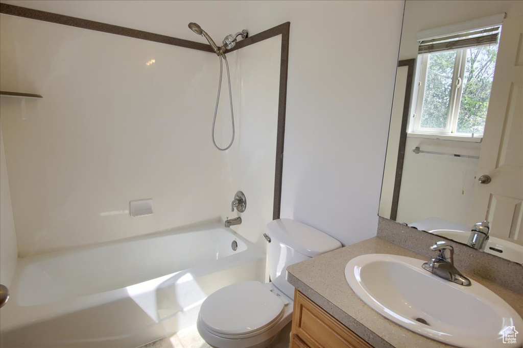 Bathroom featuring toilet, vanity, and shower / washtub combination