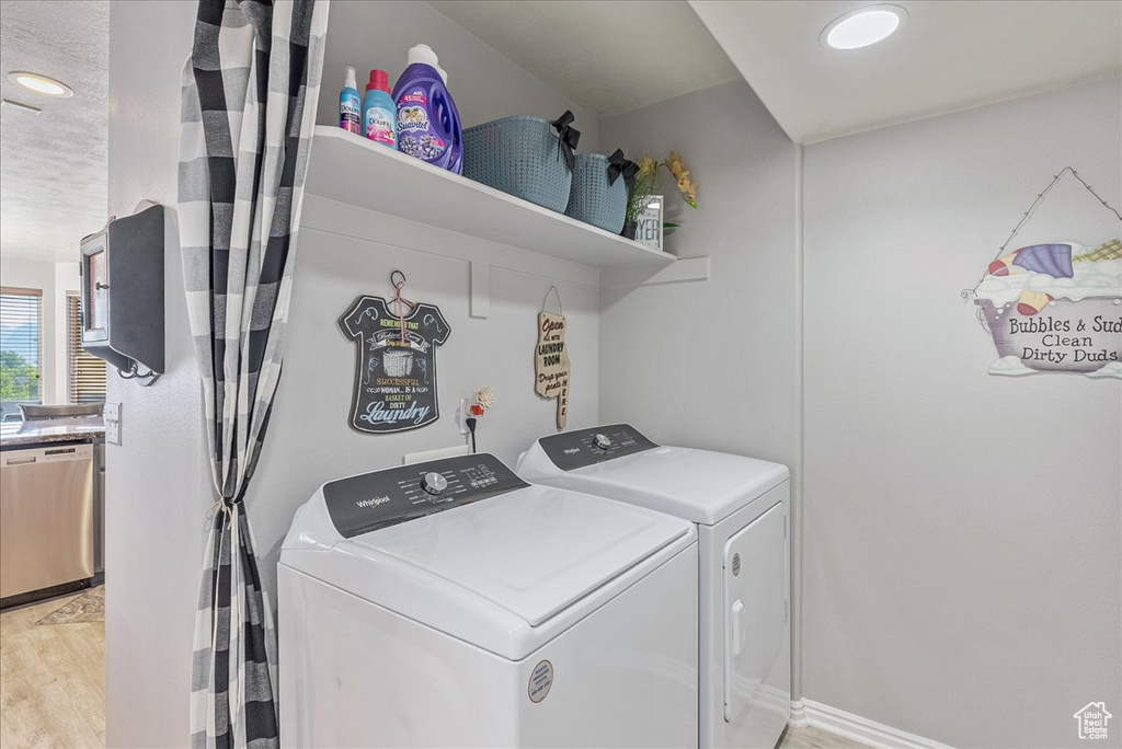 Washroom with separate washer and dryer, light wood-style floors, and recessed lighting
