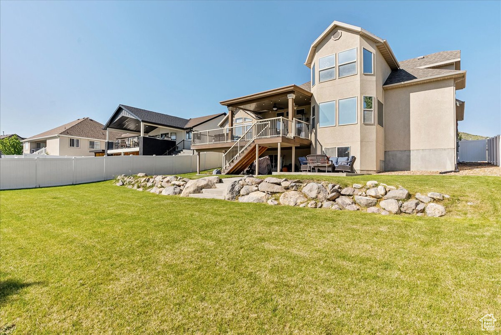 Rear view of property featuring a ceiling fan, stairway, a wooden deck, and stucco siding