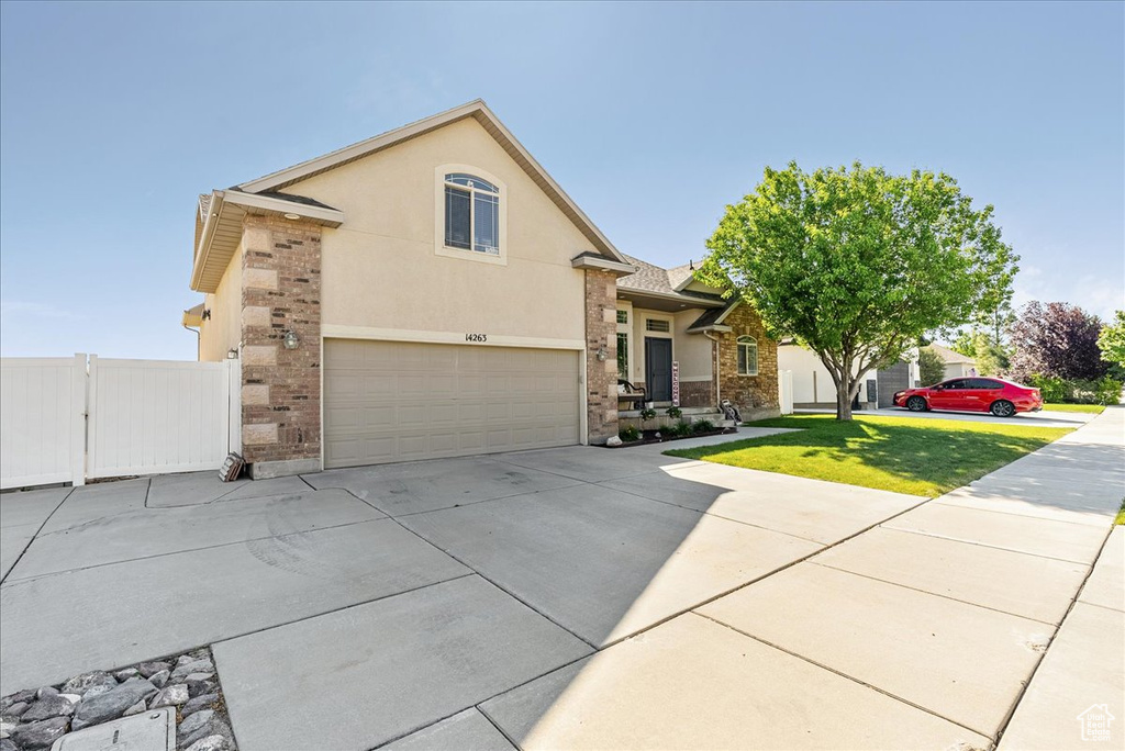 View of front of property featuring concrete driveway, an attached garage, and stucco siding