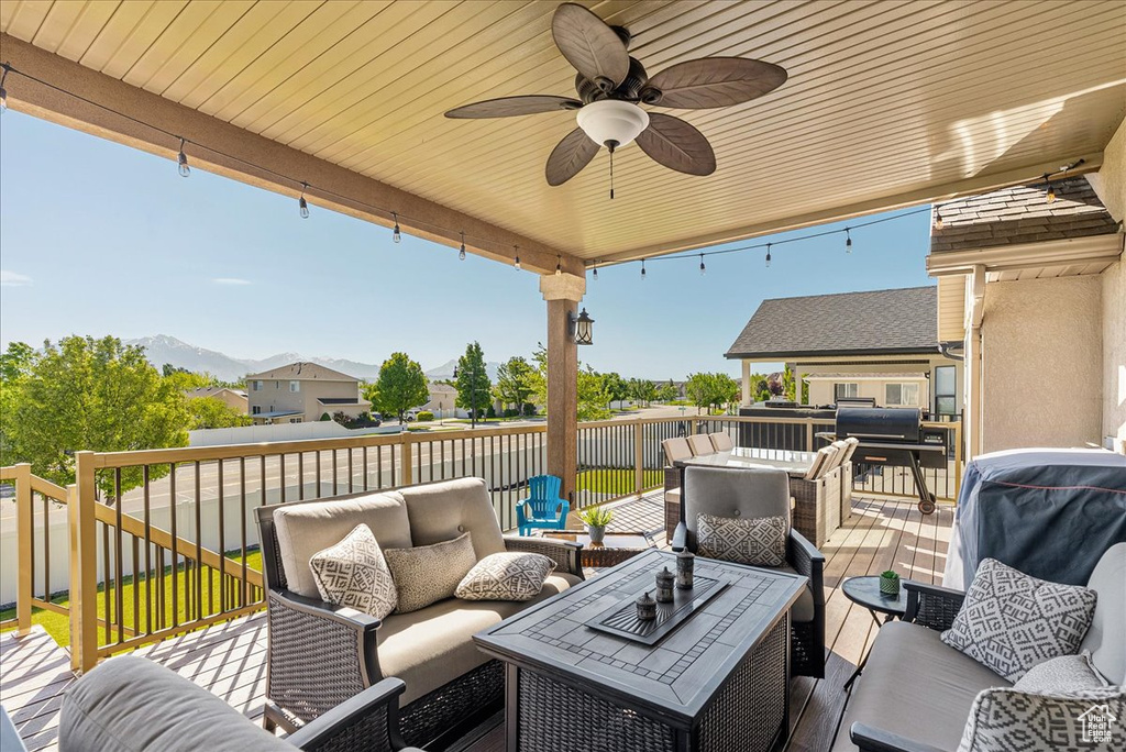View of patio / terrace featuring an outdoor living space, a deck with mountain view, a ceiling fan, and outdoor dining space