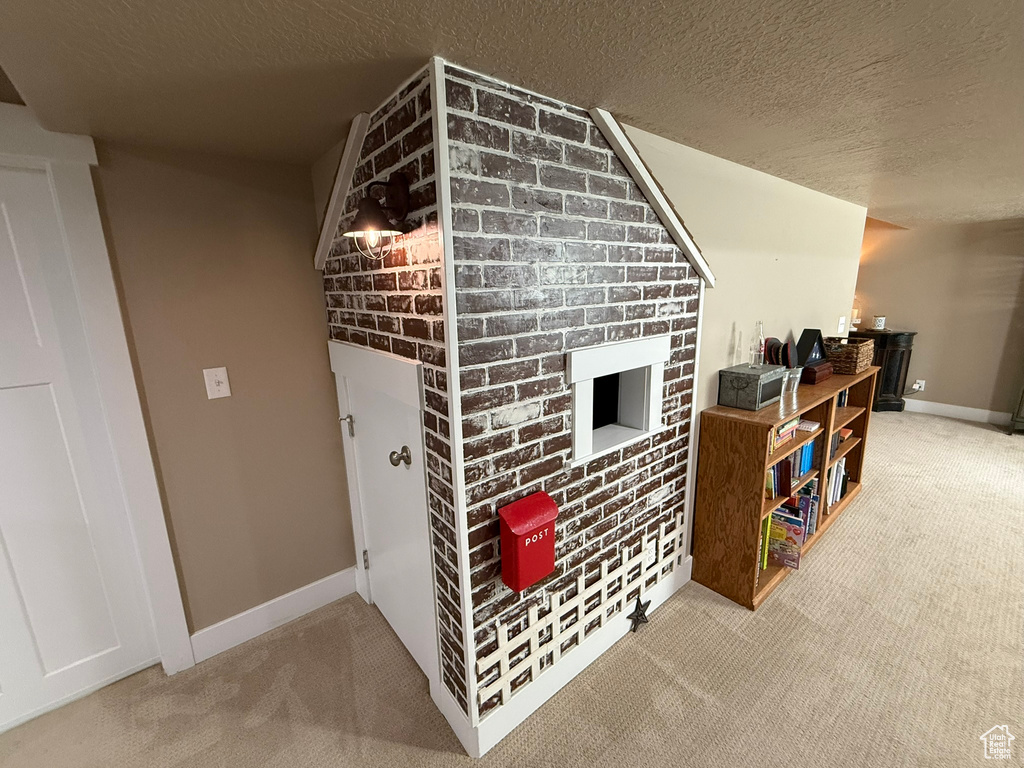 Bonus room featuring carpet floors, a textured ceiling, and baseboards