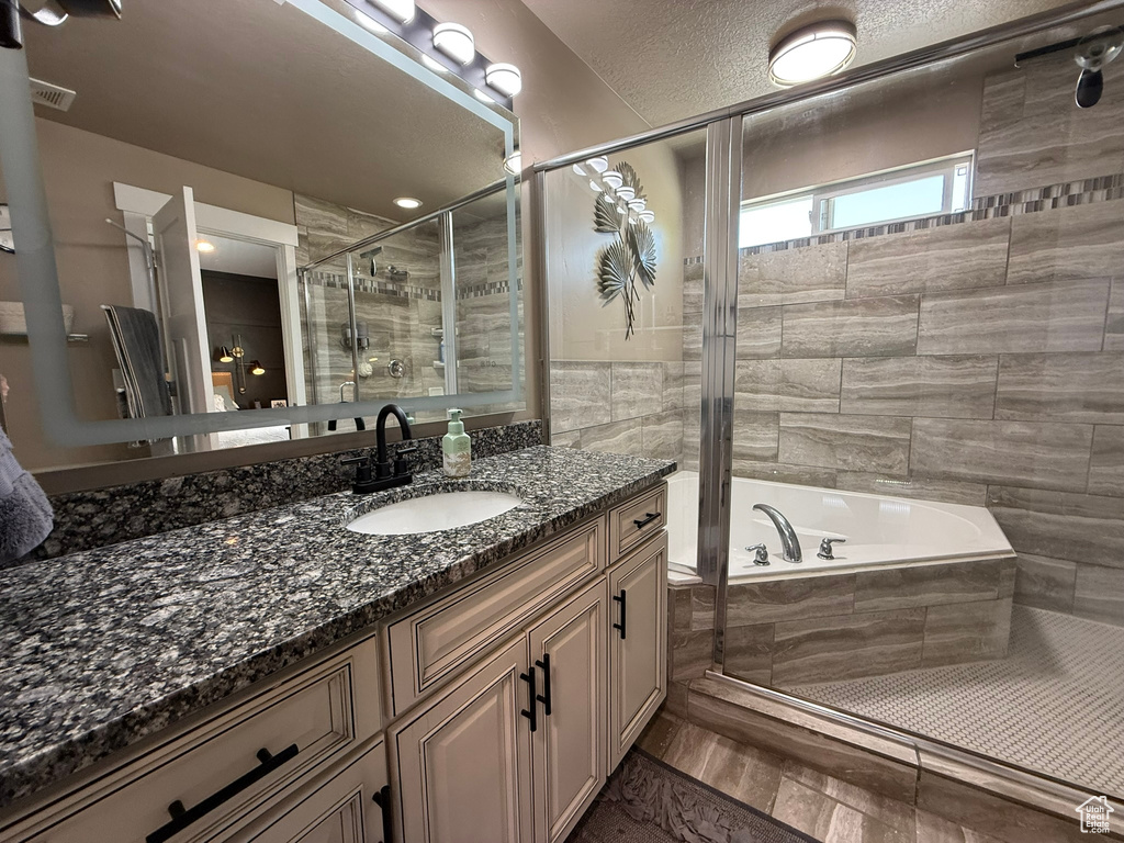 Bathroom featuring a stall shower, vanity, and a bath