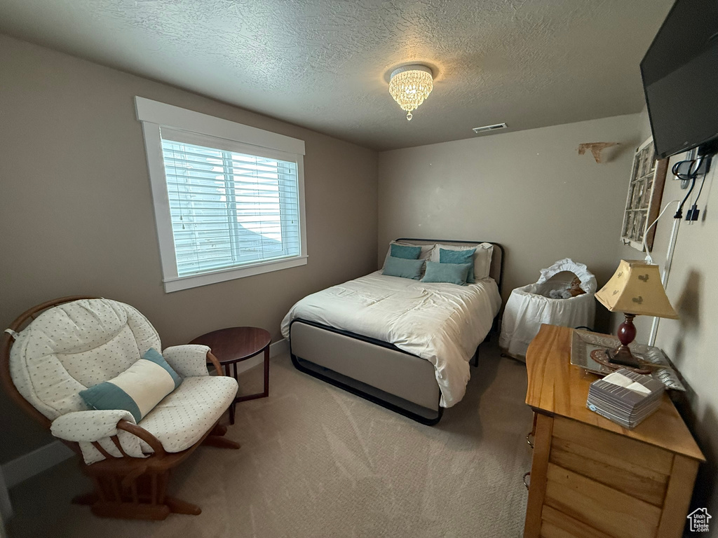 Bedroom featuring a textured ceiling and carpet flooring