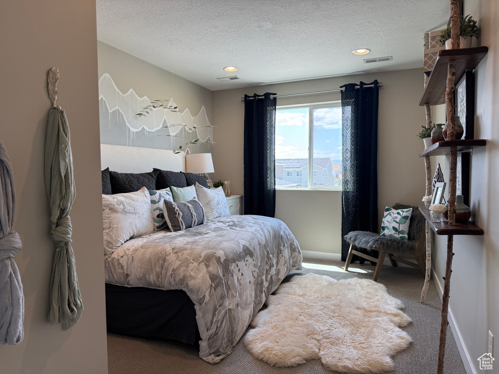 Carpeted bedroom with a textured ceiling, recessed lighting, and baseboards
