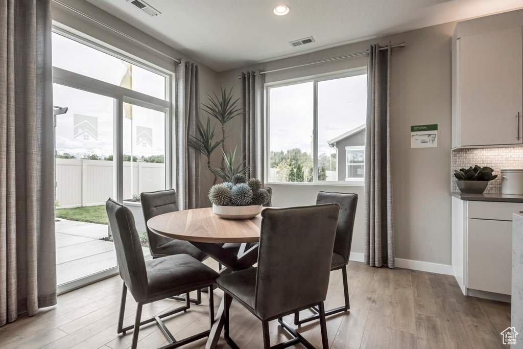 Dining area with plenty of natural light, light wood-style flooring, recessed lighting, and baseboards